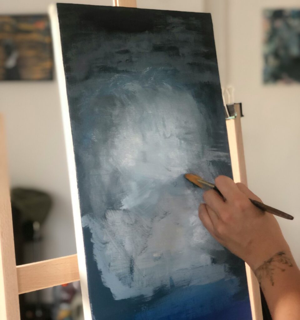 A person is painting a picture on a easel