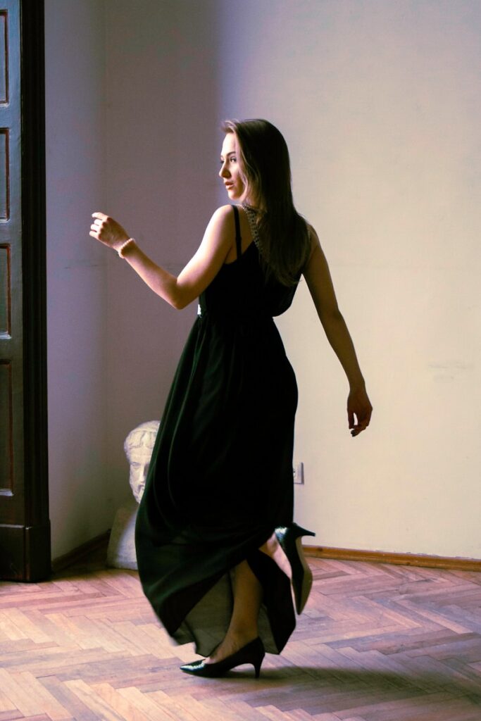 a woman in a black dress is dancing