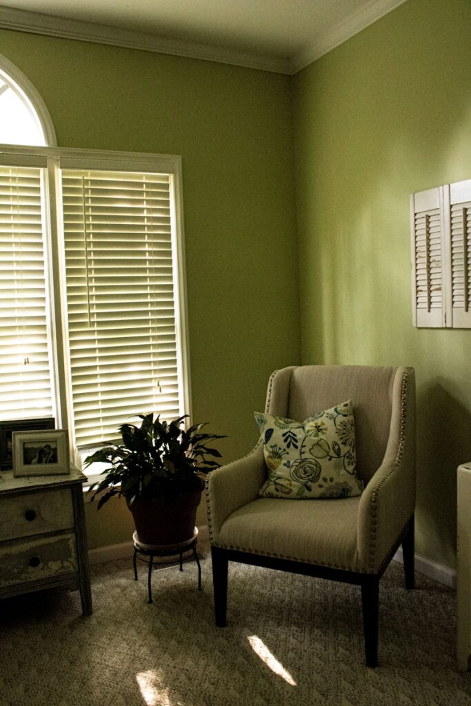 A living room with green walls and a chair