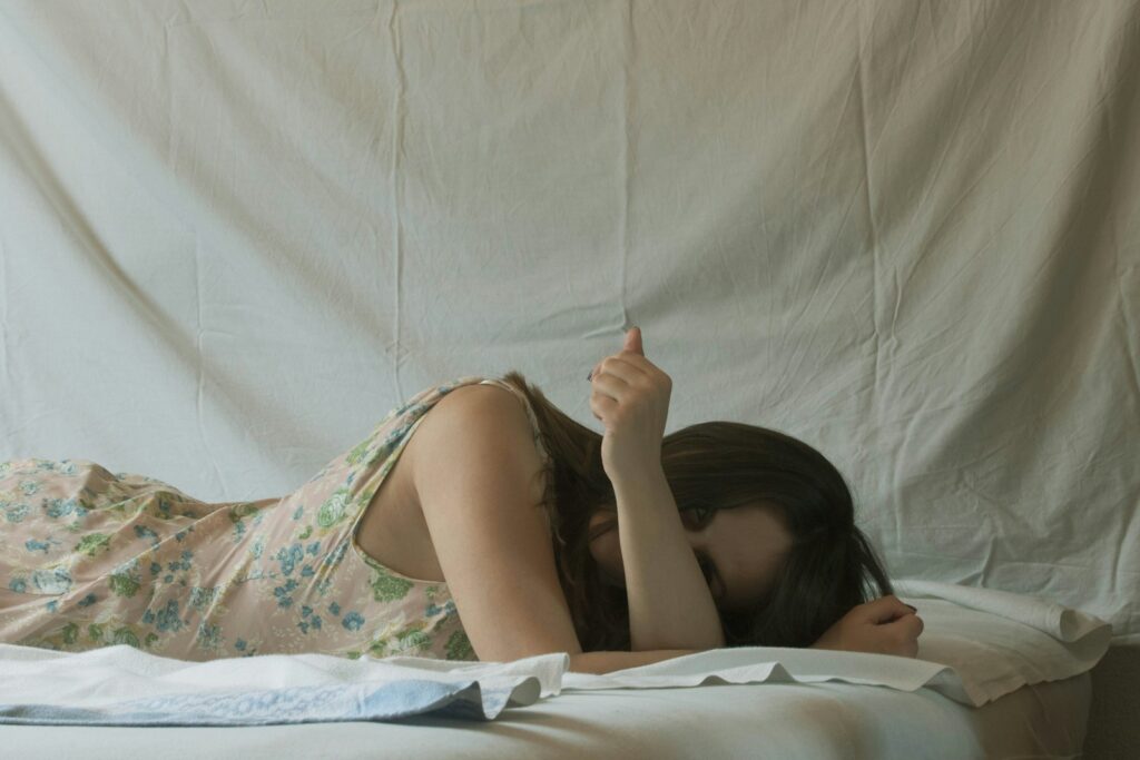 woman in white green and pink floral dress lying on bed