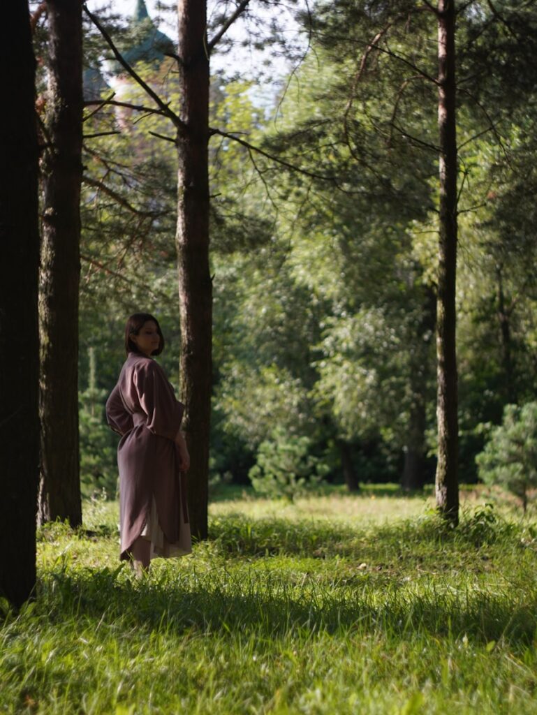 A woman standing in the middle of a forest
